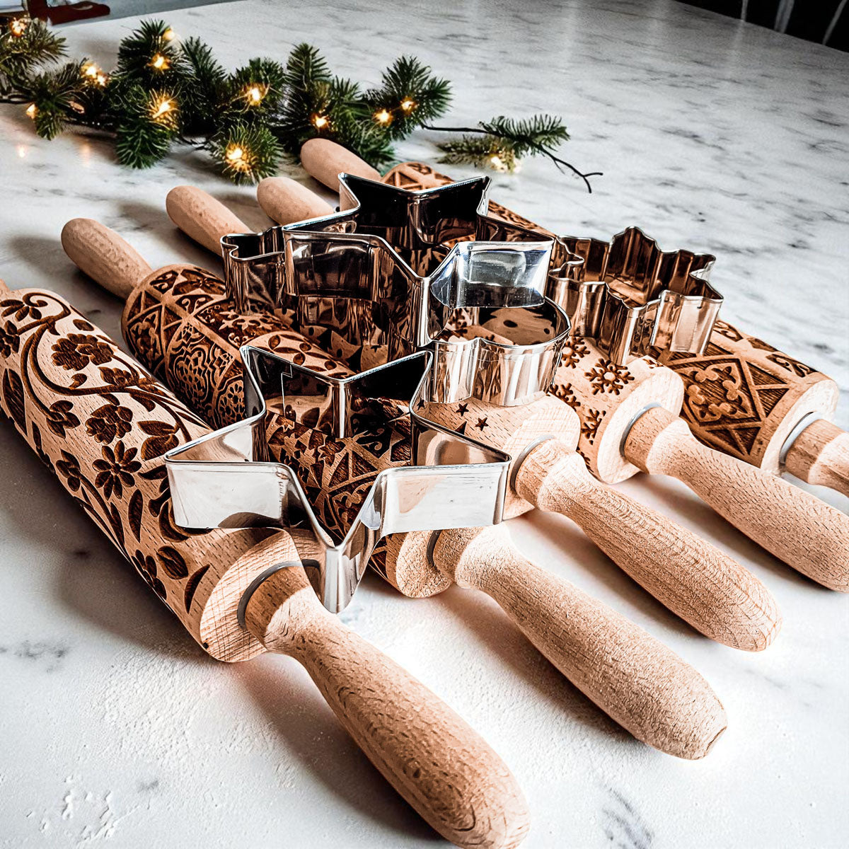 Assorted wooden Christmas rolling pins with patterned barrels and metal cookie cutters.