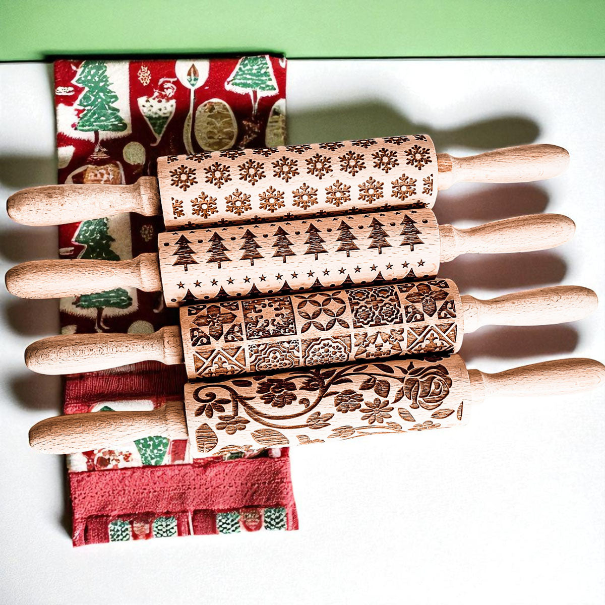 Christmas rolling pin set with patterned wooden rollers stacked with handles.