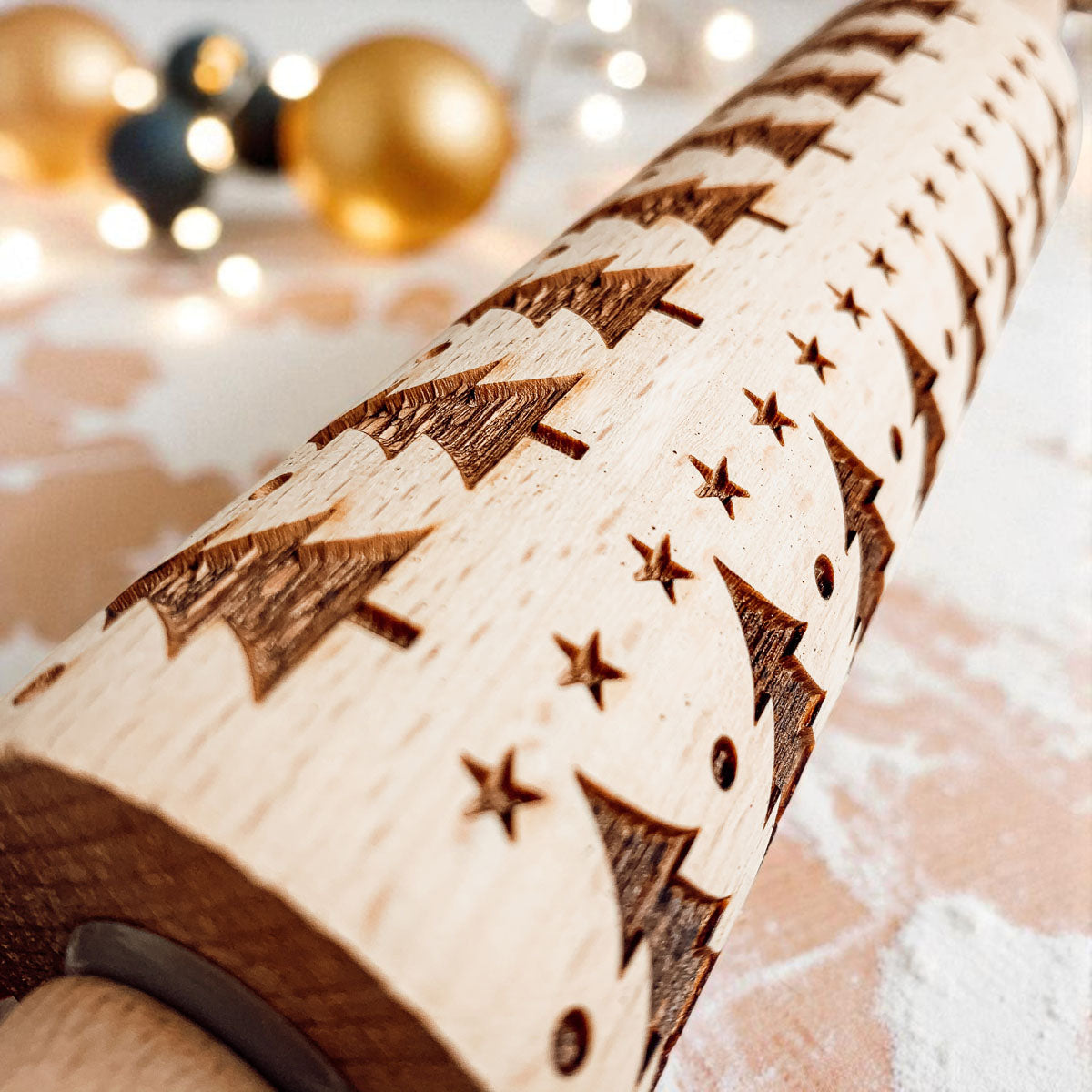 Close-up of embossed wooden rolling pin with Christmas tree and star motifs