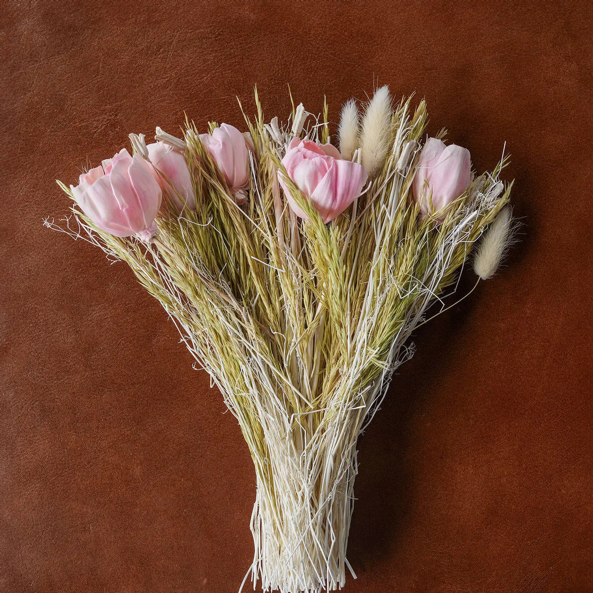 Dried floral bouquet with light pink tulip-like blooms and pale grasses
