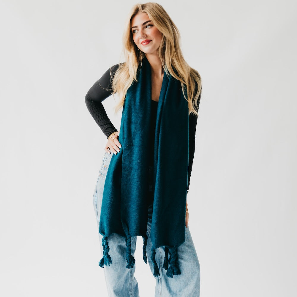 Twisted tassel scarf in teal, draped over the front with dangling tassels