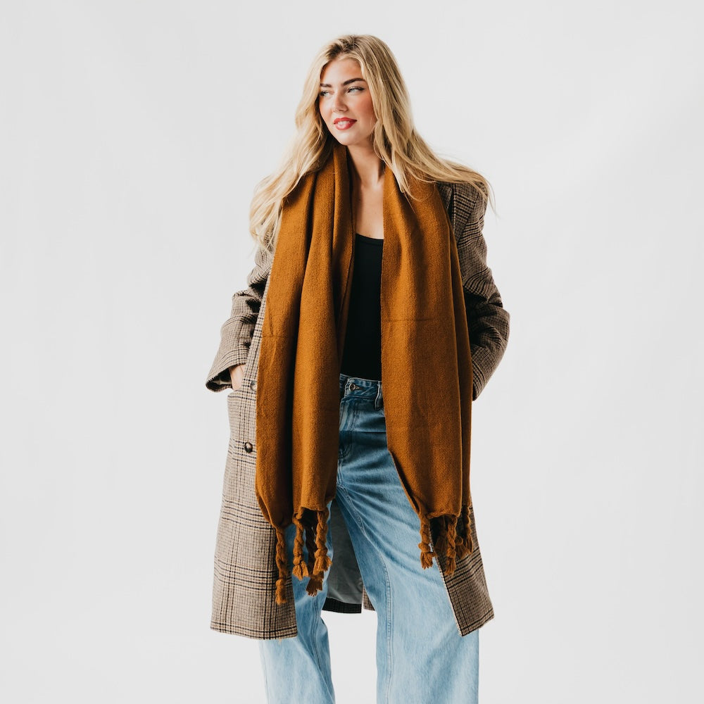 Twisted tassel scarf in caramel brown, scarf draped over the chest with tassels