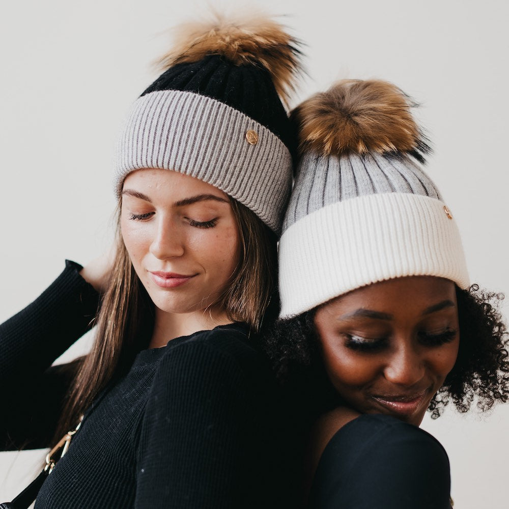 Two-tone knit beanies with brown fur pom: gray and cream ribbed styles