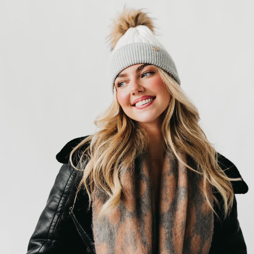 Two-tone knit beanie with brown fur pom and light gray ribbed cuff