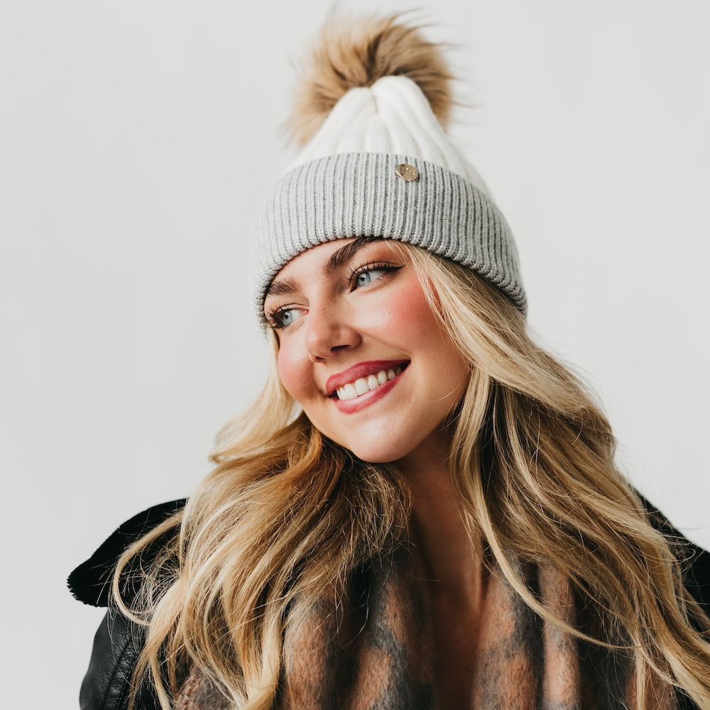 Two-tone knit beanie with brown fur pom and light gray ribbed cuff