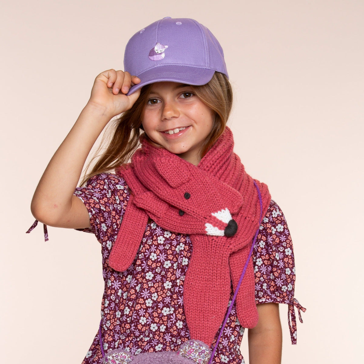 Purple fox-patch baseball cap worn by a child, showing the front and curved brim