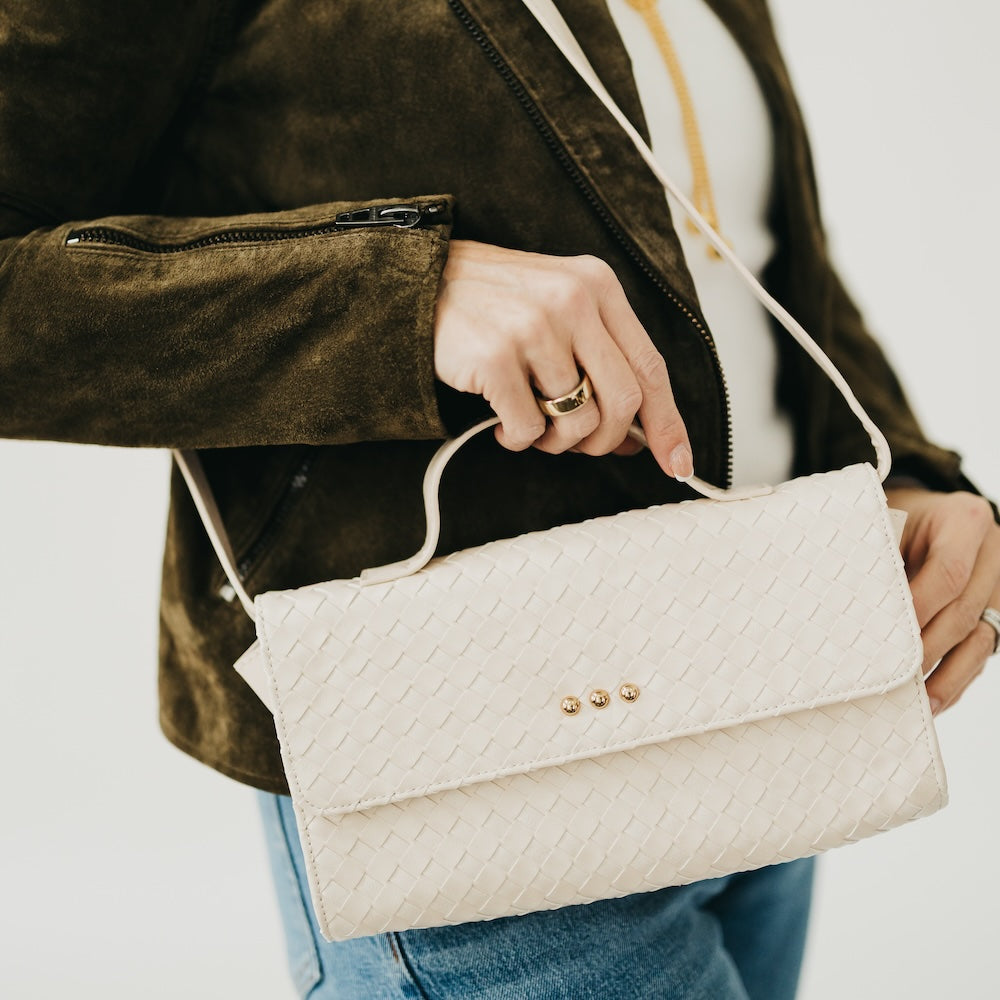 Cream woven foldover clutch bag with snap front and chain shoulder strap
