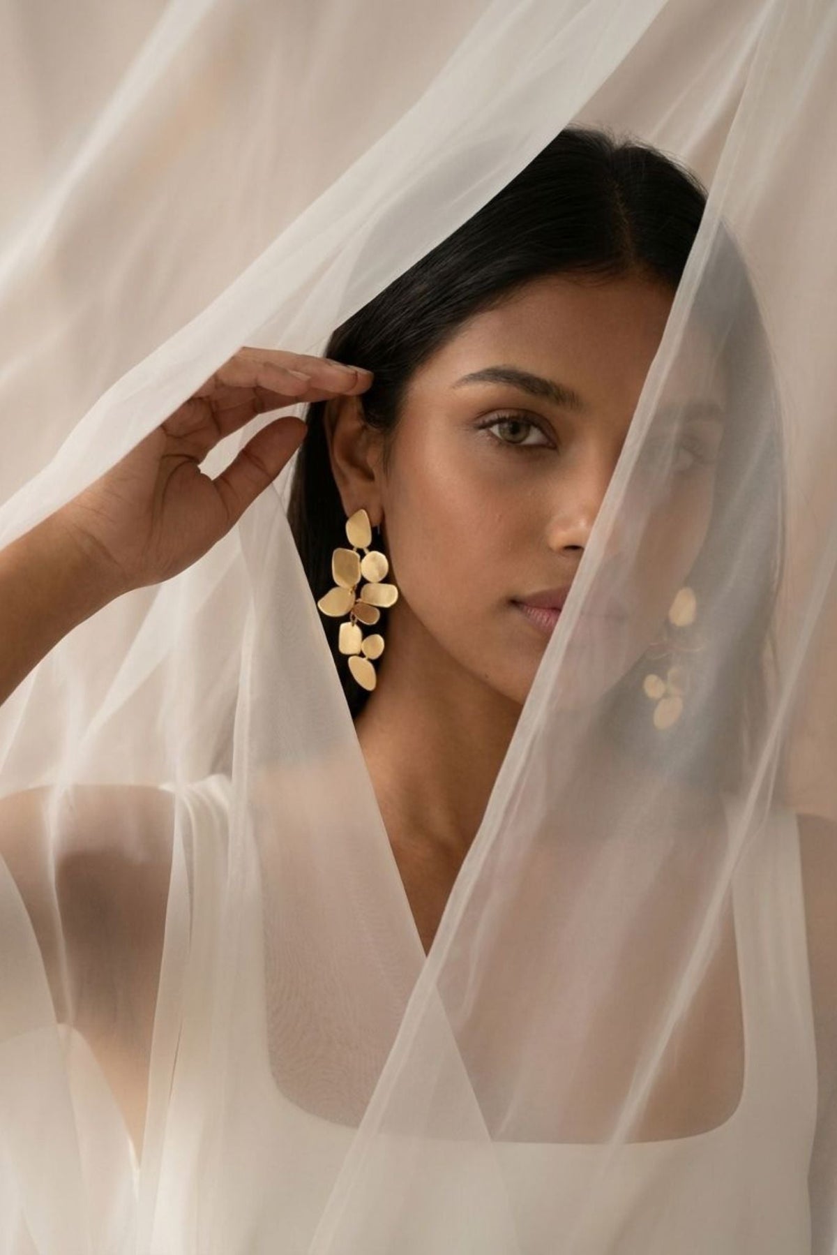 Gold-tone leaf-disc dangle earrings on model, long statement drop with multiple pieces