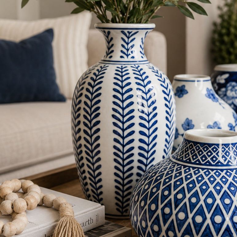 Tall blue and white ceramic vase with leaf-style pattern and narrow neck