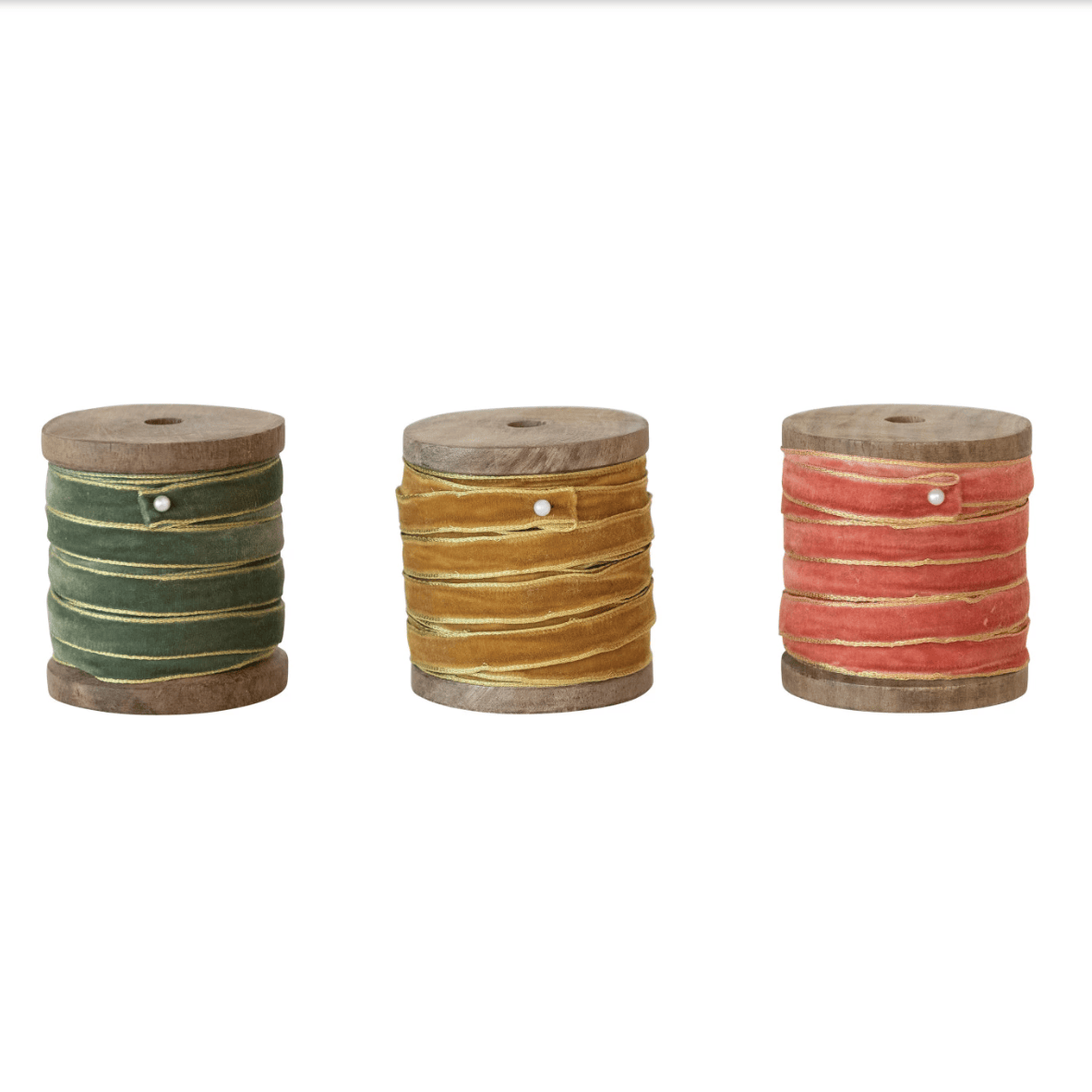 Velvet ribbon with metallic edge spools in green, gold, and coral with ribbon tails