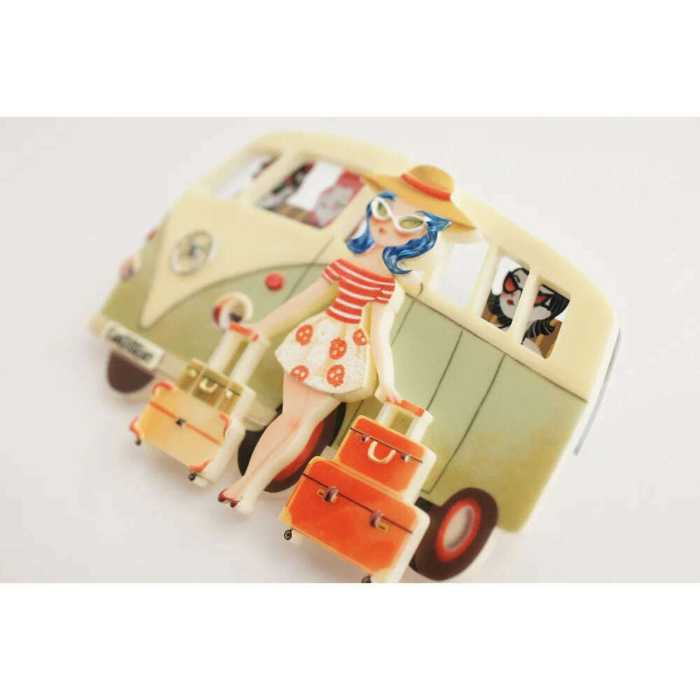 Vintage van brooch with blue-haired woman and orange luggage on cream van