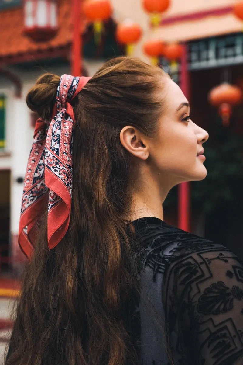 Vine motif bandana scarf, brick red with black-and-cream paisley trim, tied in hair