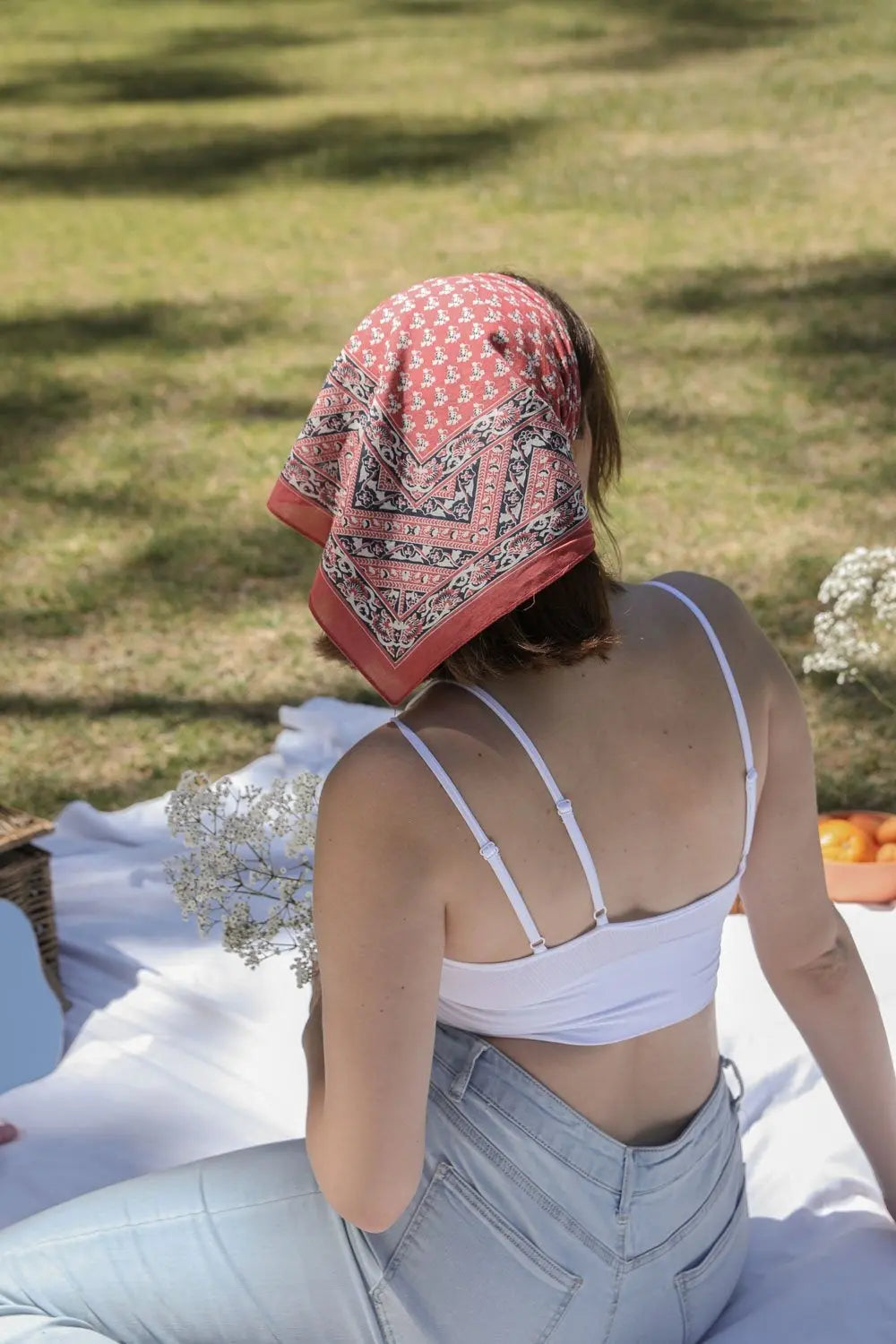 Vine motif bandana scarf, brick red with repeating motifs and paisley border, tied on head