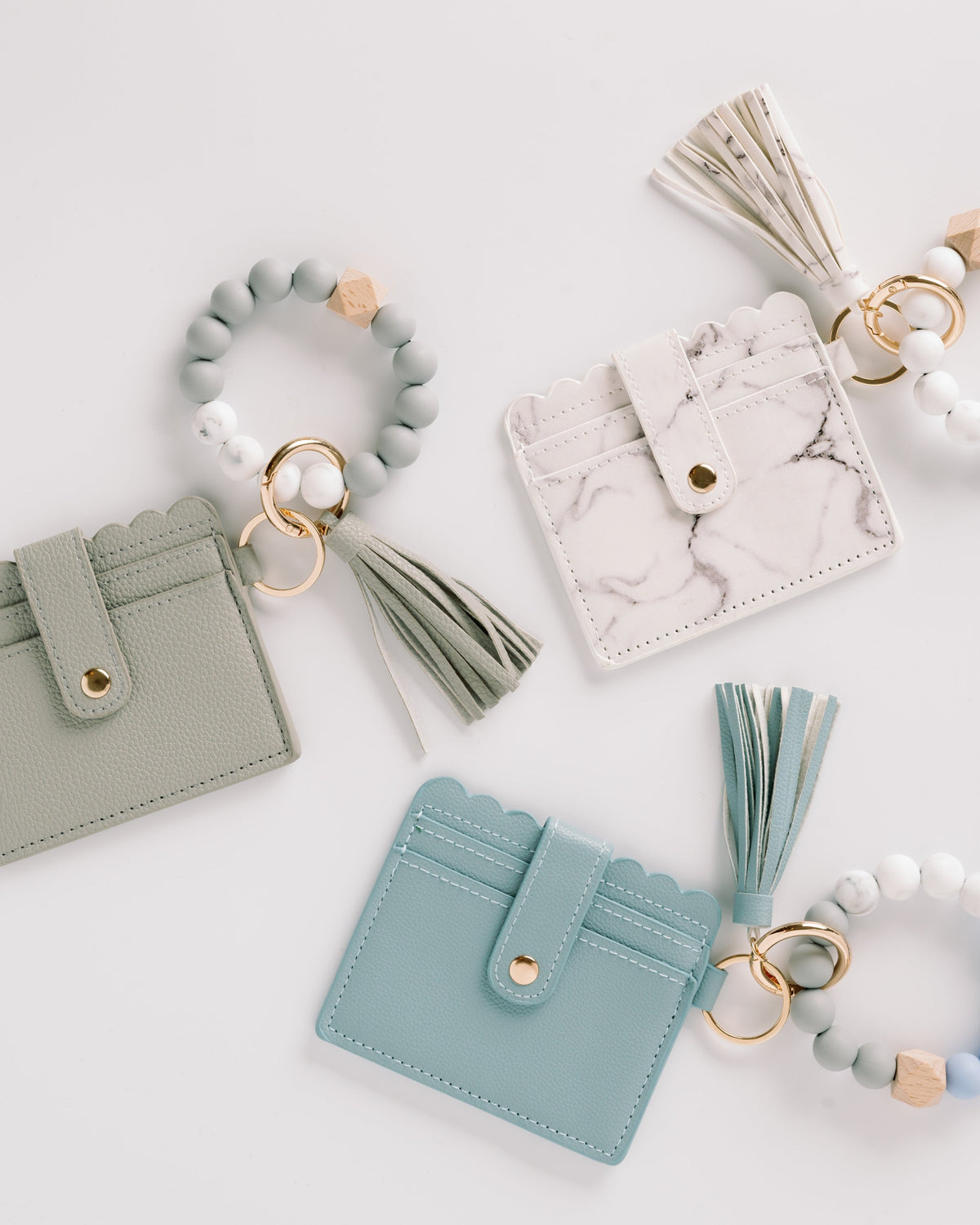 Sage green, white marble, and light blue wallet wristlet keychains with tassels and beaded keyrings