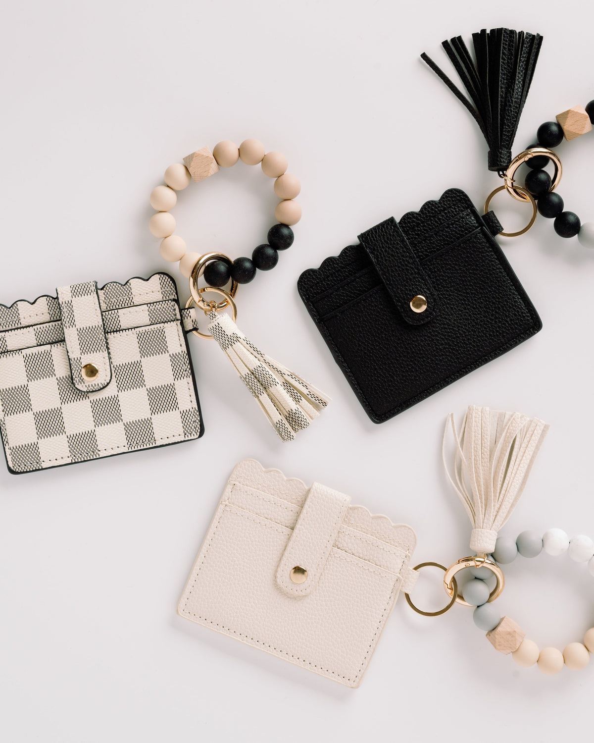 Black, plaid, and cream wallet wristlet keychains with tassels and beaded keyrings