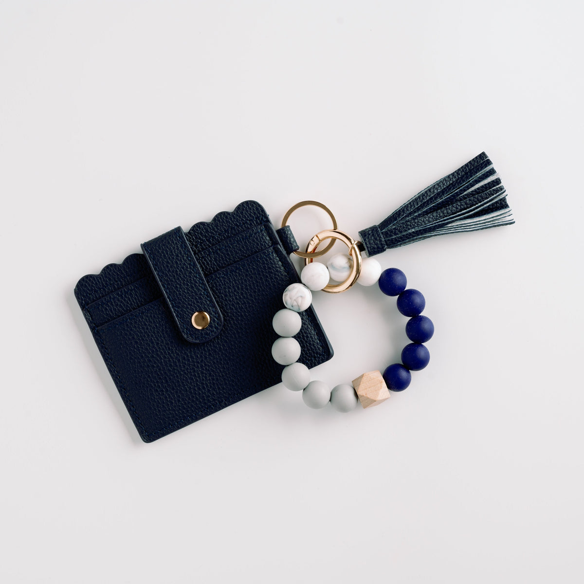 Navy wallet wristlet keychain with navy tassel and beaded white-and-blue charm ring.