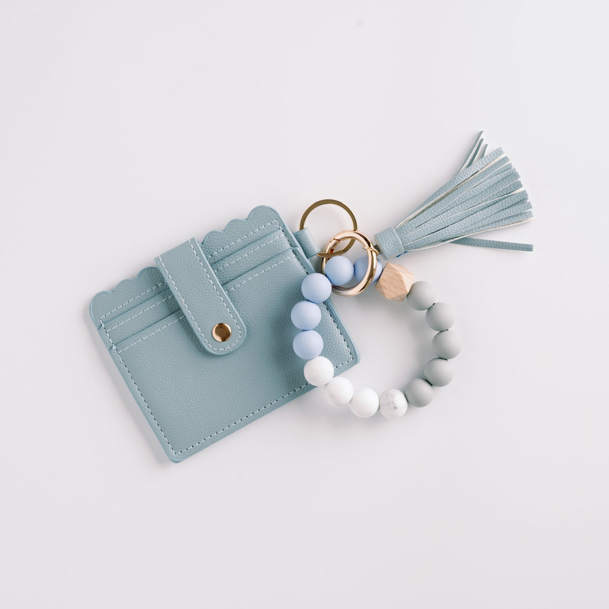 Light blue wallet wristlet keychain with tassel, beaded bracelet ring, and snap flap.