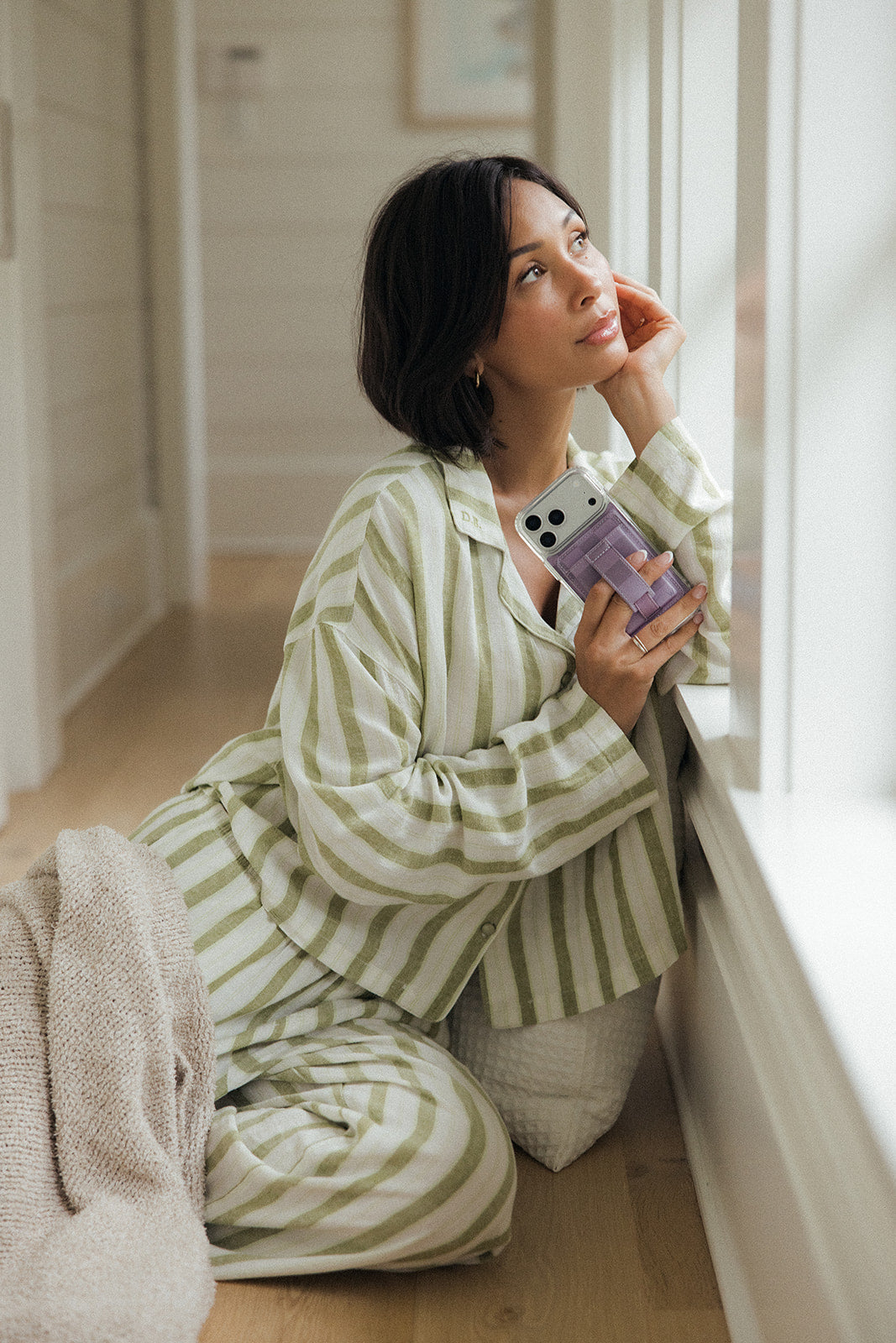 Lavender magnetic phone wallet attached to a smartphone, held in front of the face.