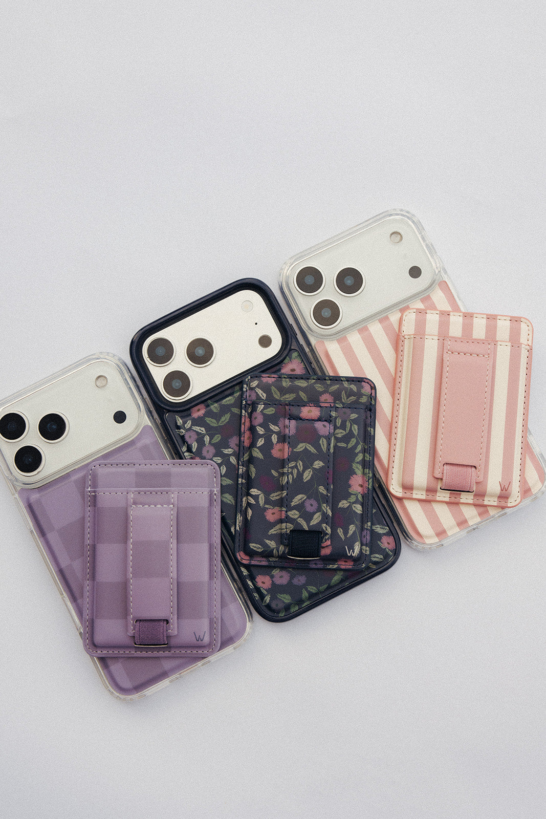 Assorted magnetic phone wallets in purple and pink tones, each with card slots and strap.
