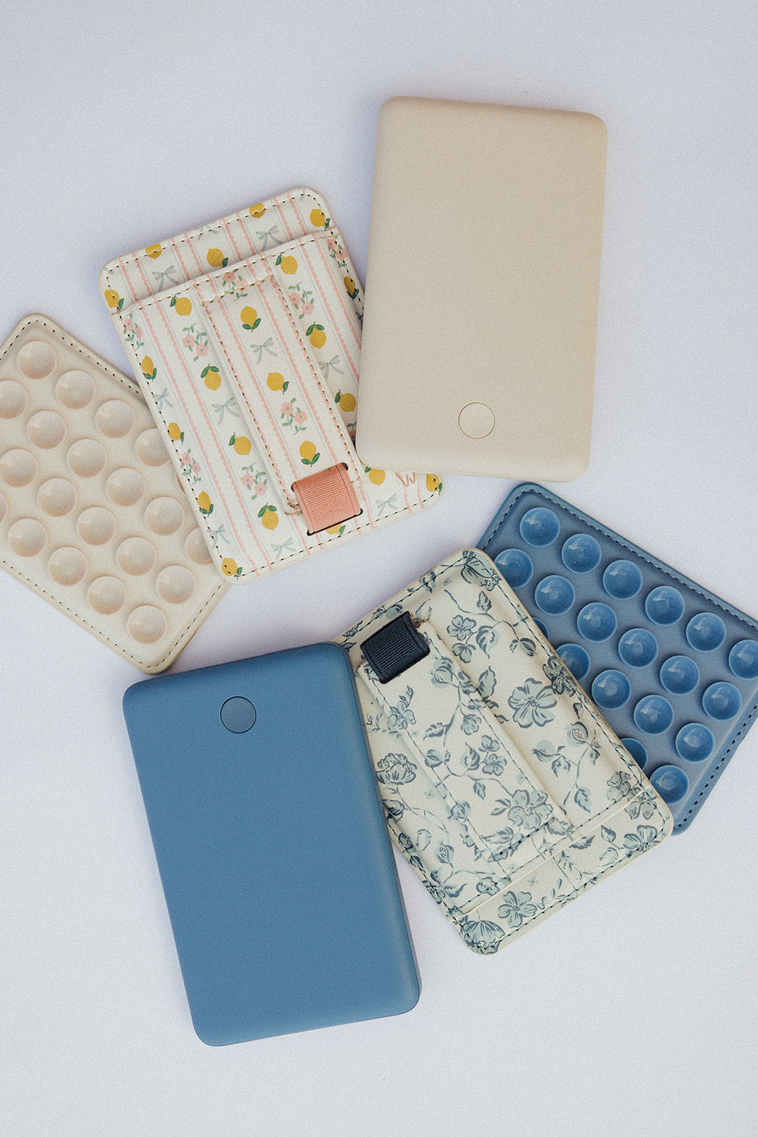 Assorted magnetic phone wallets: blue solid, floral pattern, and chart print