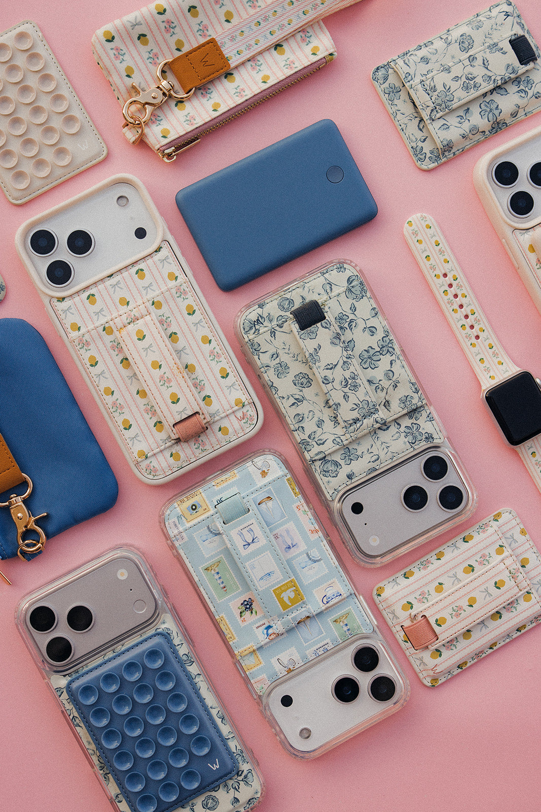 Assorted magnetic phone wallets on pink background: floral, blue solid, and pop styles