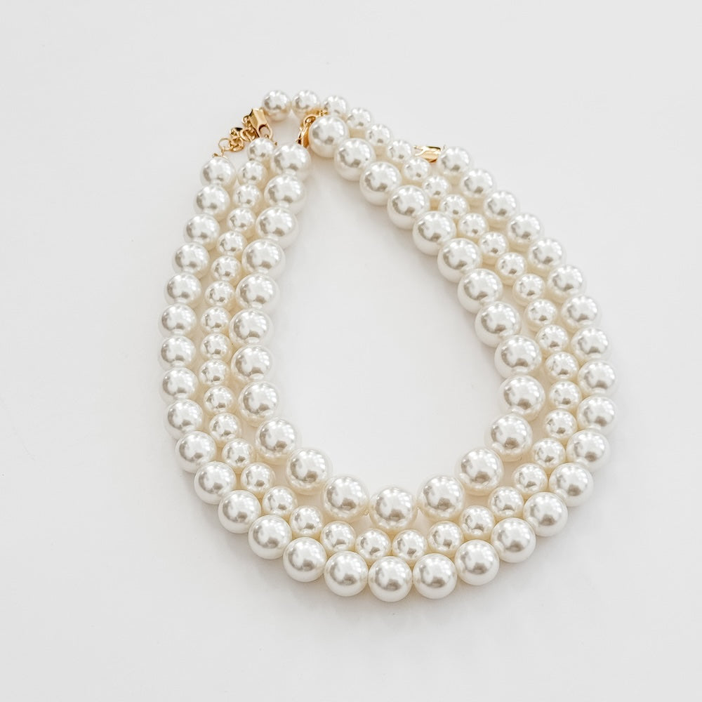 Chunky pearl three-row necklace, white round pearls with gold-tone end hardware