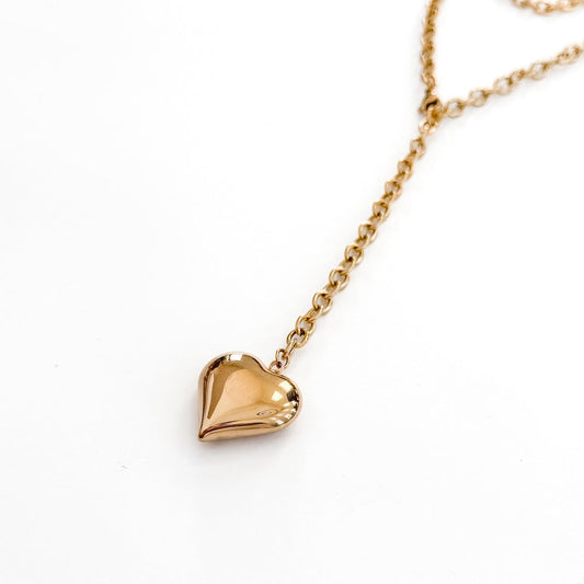 Gold-tone heart pendant on a layered chain necklace with wrapped design
