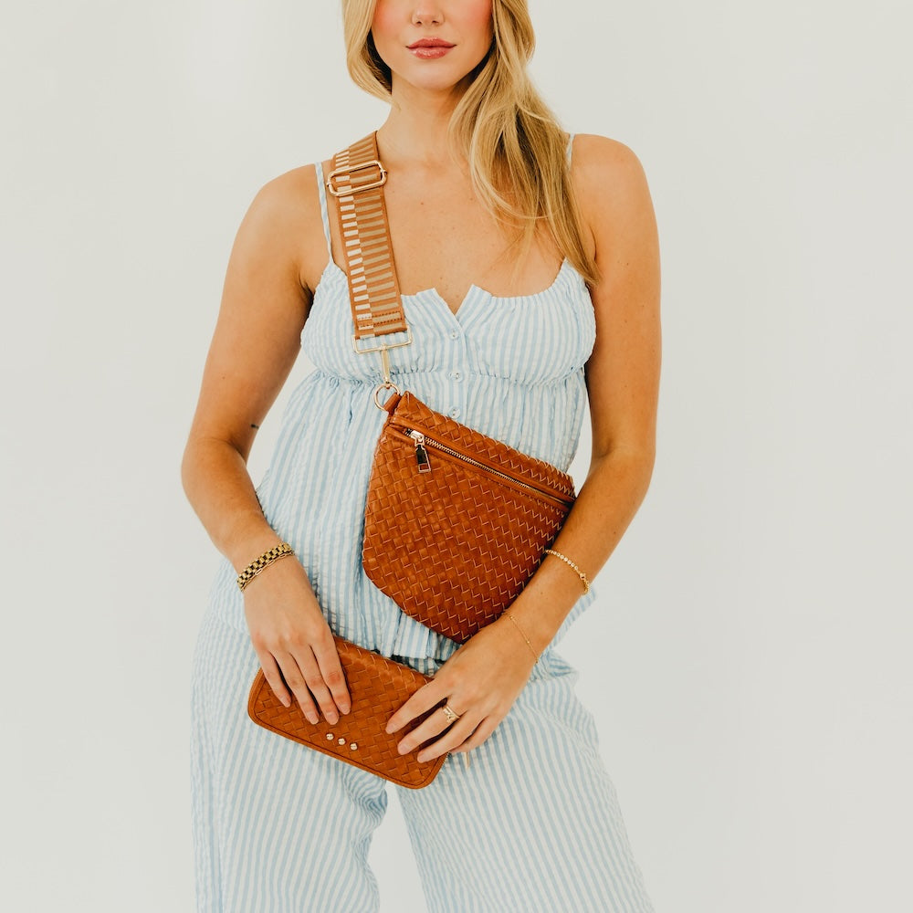 Brown woven bum bag with zipper top and adjustable crossbody strap.
