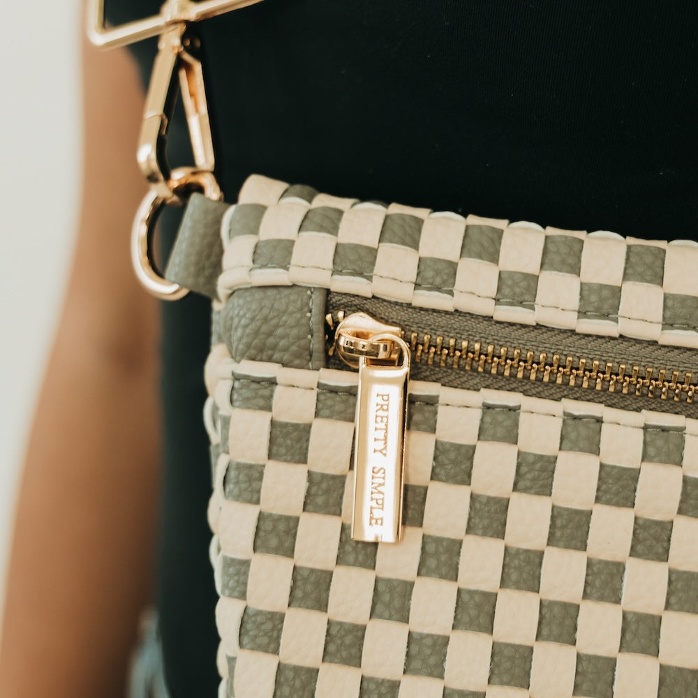 Westlyn woven bum bag close-up, green-and-cream checkered with gold zipper and belt clip