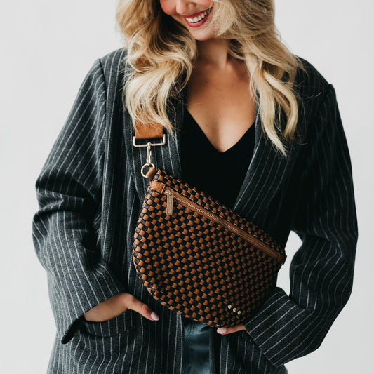 Brown woven checkered bum bag with zipper top and adjustable crossbody strap.