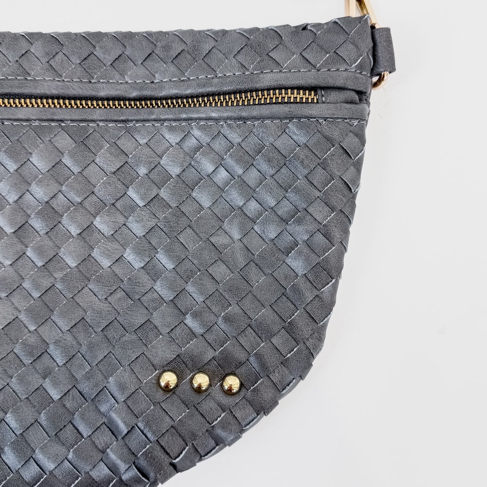 Gray woven bum bag close-up with gold zipper and small round rivets on the front flap.