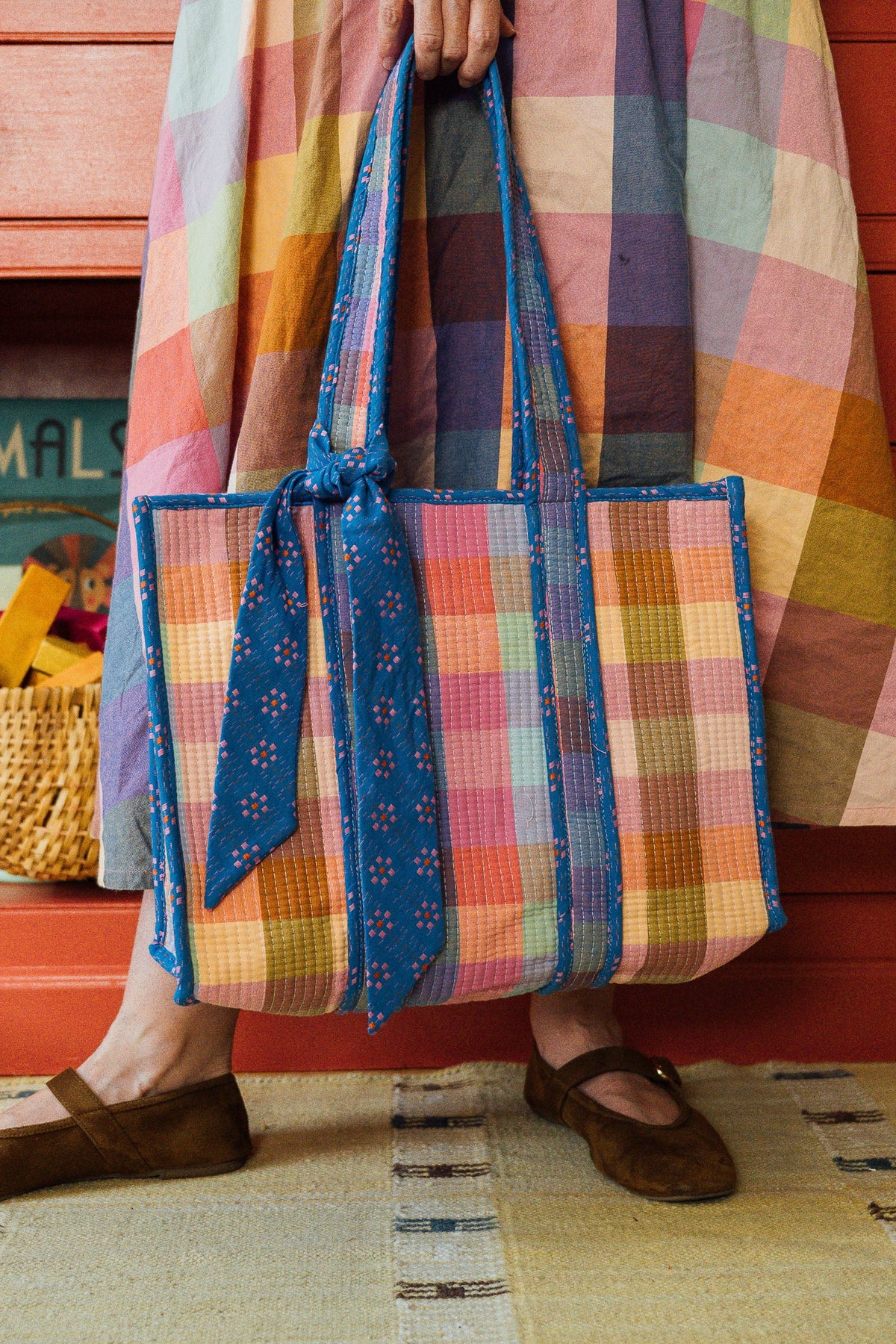 Plaid woven tote bag with blue braided handles and bow detail