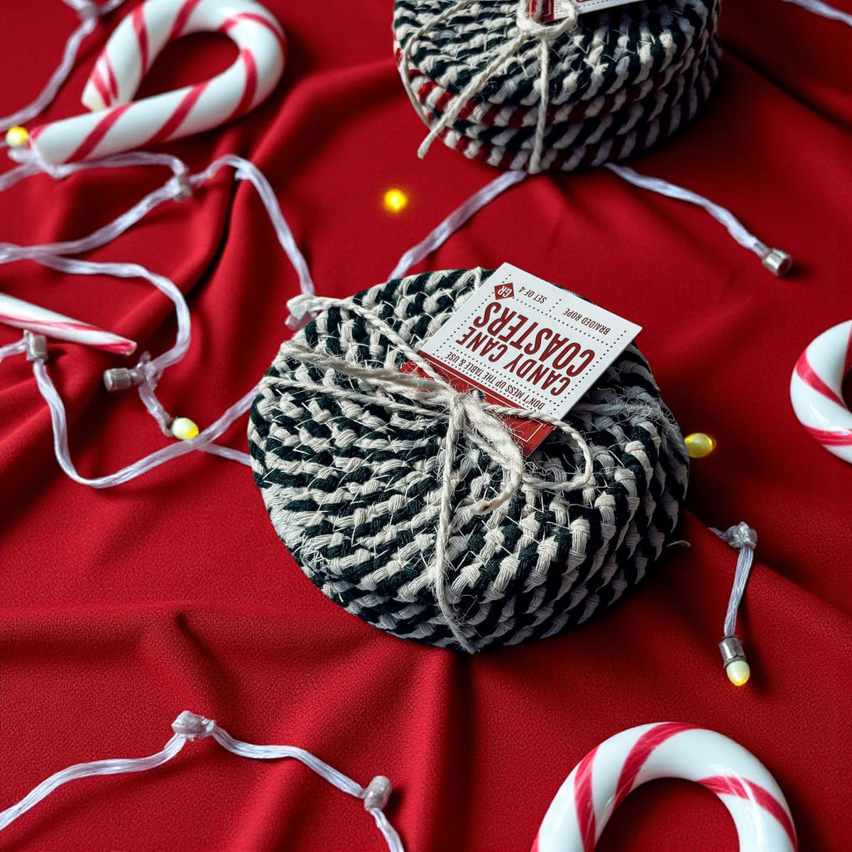 Striped braided coaster, teal and white, tied with twine on red fabric
