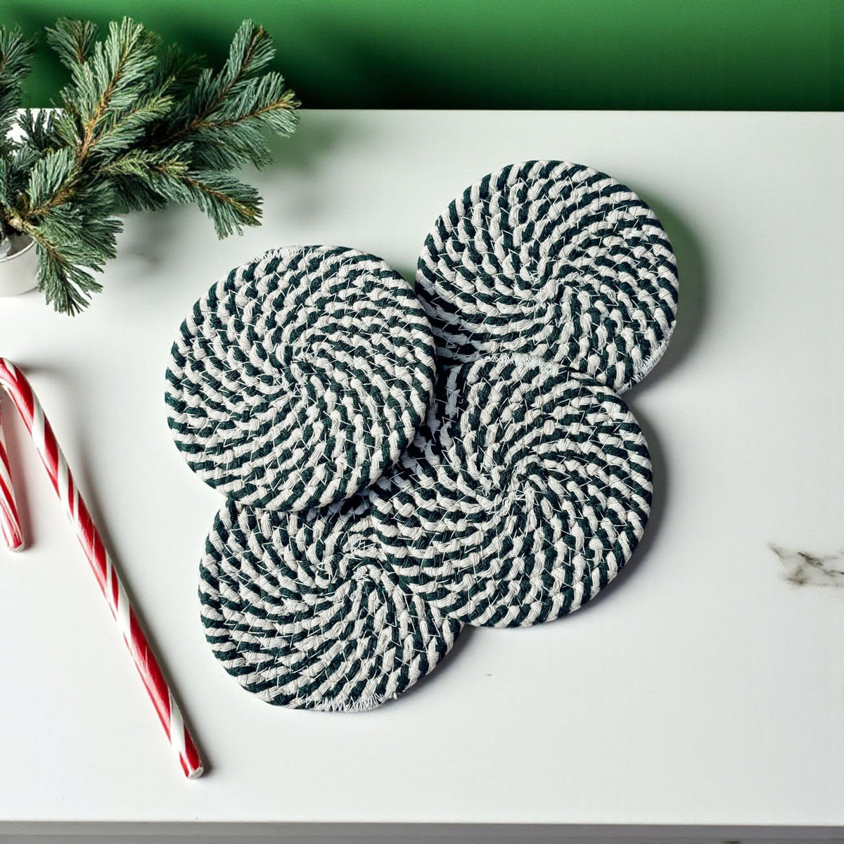 Set of 4 dark green-and-cream striped braided rope coasters, round with hanging loops