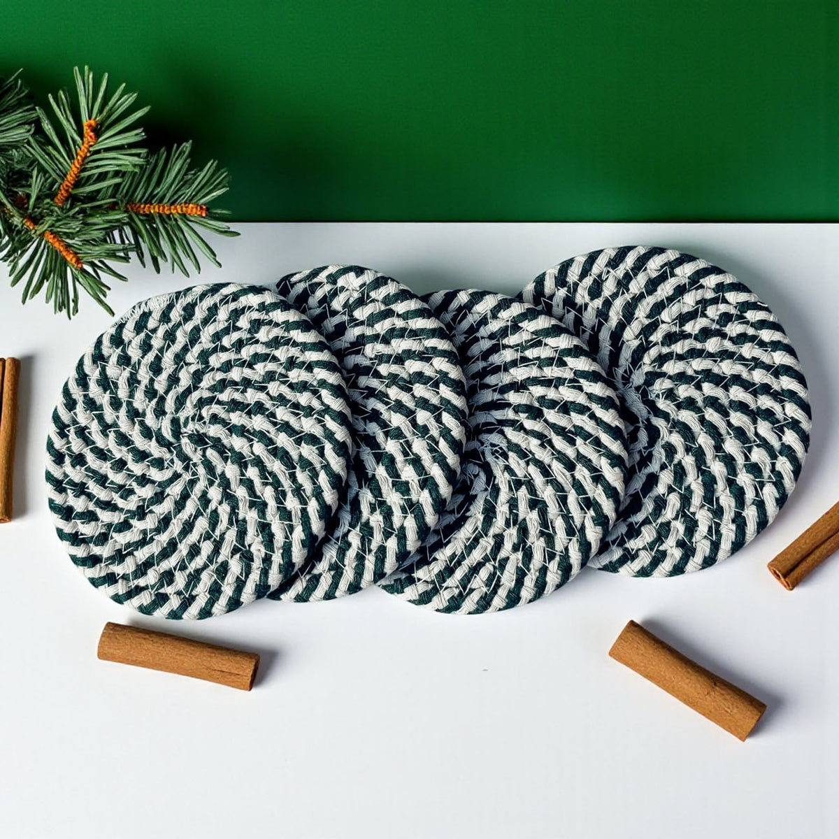 Four teal and white striped braided coasters with cinnamon sticks