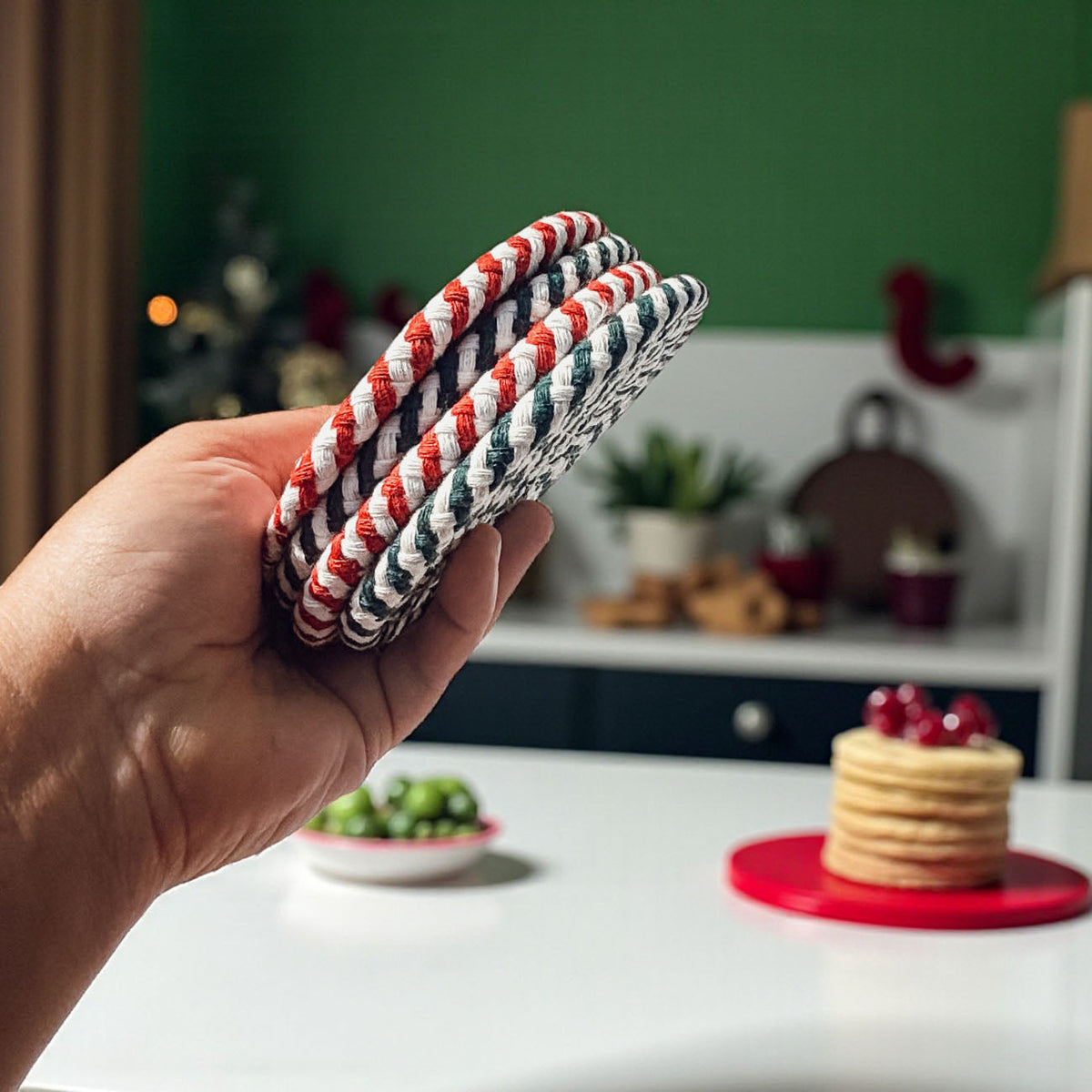Woven striped coasters in hand, red/white and teal/white