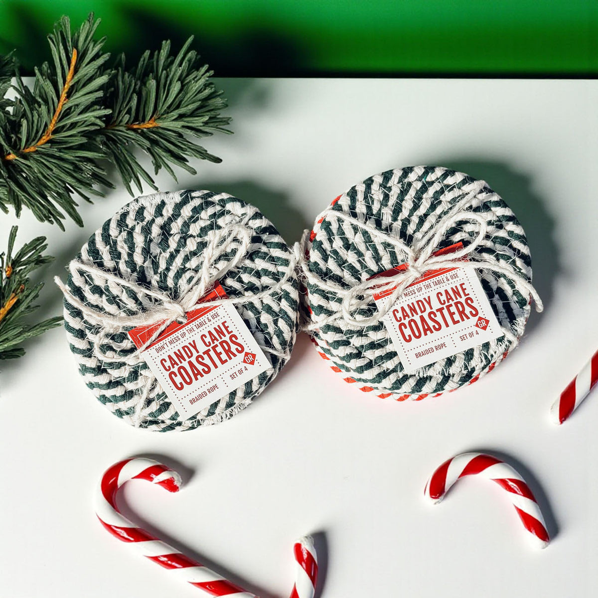 Round woven coasters with black-and-white striped pattern and red accents, pair