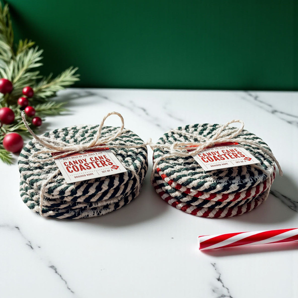 Set of 4 dark green-and-cream braided rope coasters on white marble surface