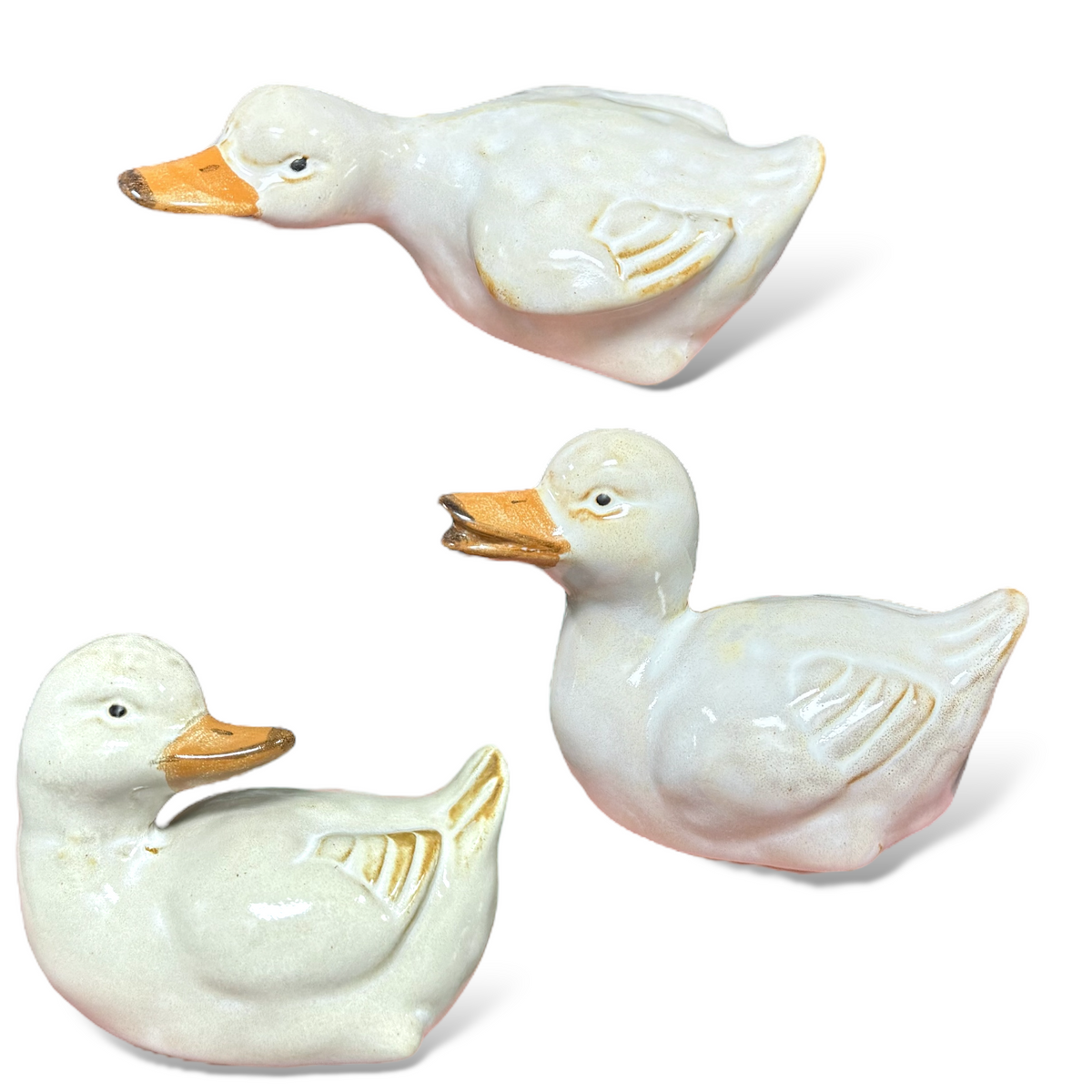 Glazed ceramic duckling figurines set of three, pale white bodies with orange beaks