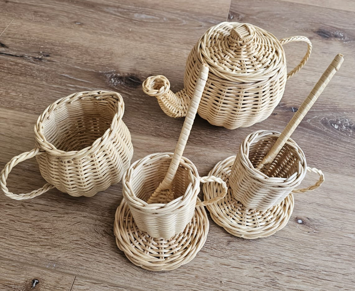 Wicker play tea set with lidded teapot, three cups, saucers and stirrers