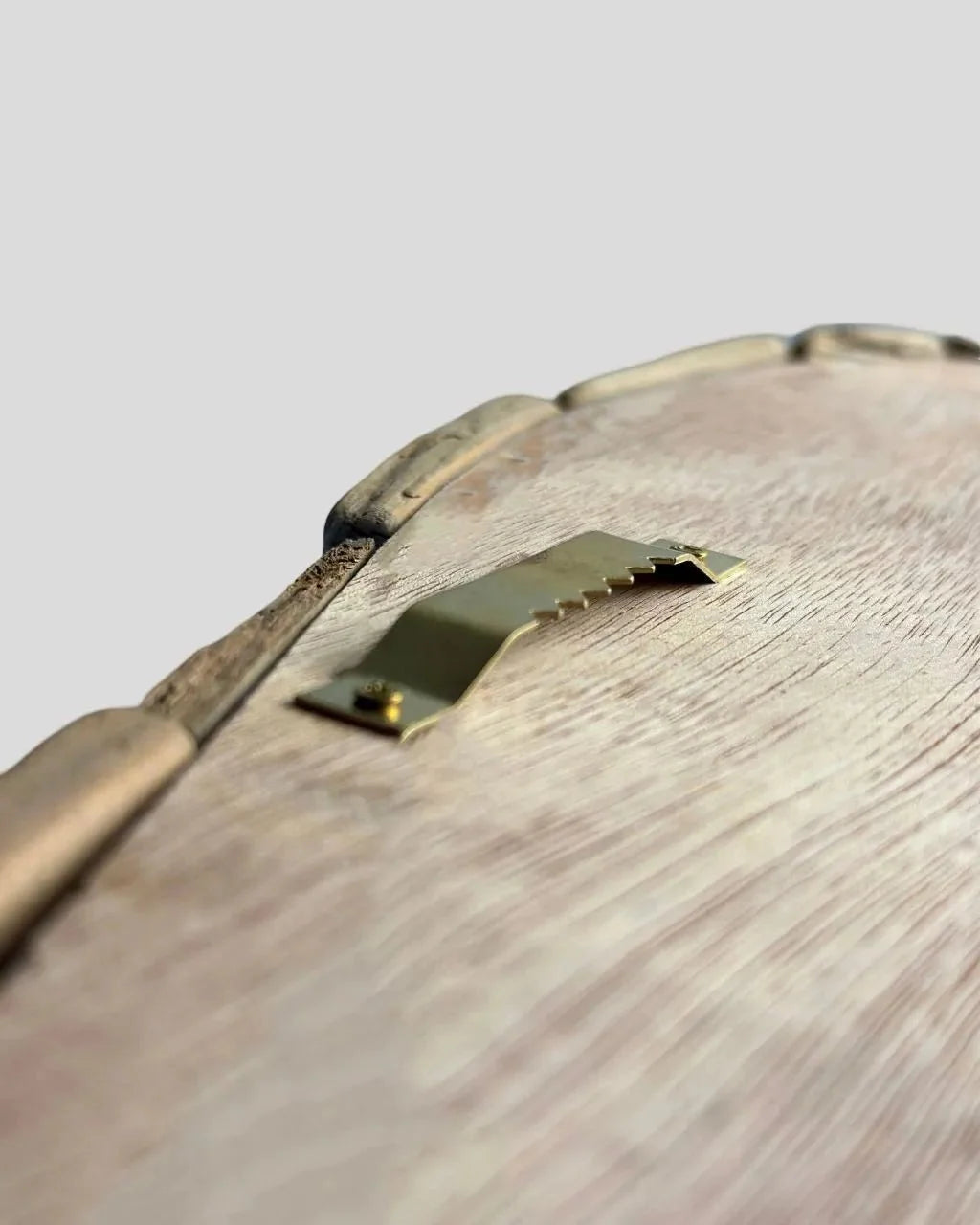 Back of wooden whale wall art with a metal sawtooth hanging bracket.