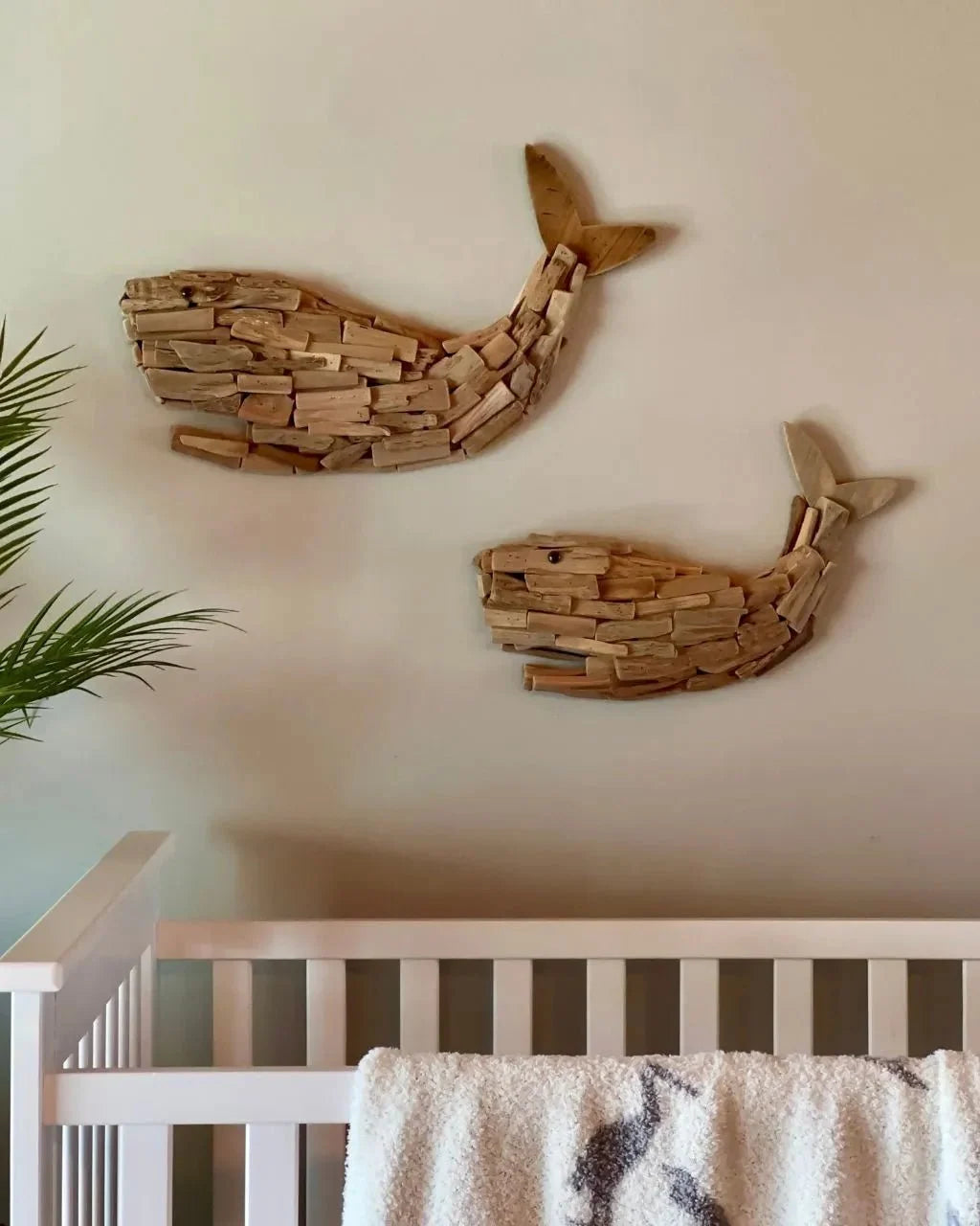 Two wooden whale wall decorations made from layered wood pieces.