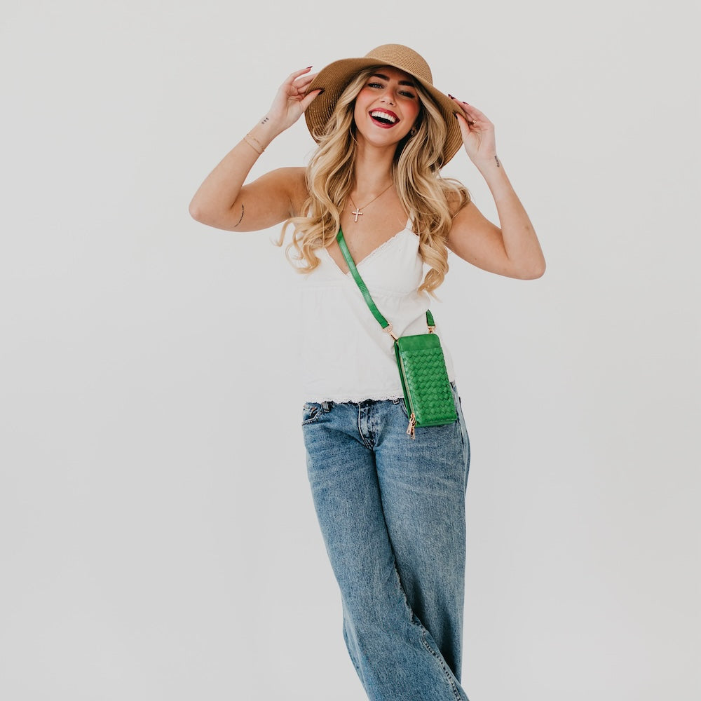 Woven phone bag in green with long crossbody strap and rectangular front pocket