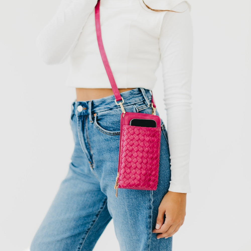 Woven phone bag in pink with adjustable crossbody strap and zipper pocket