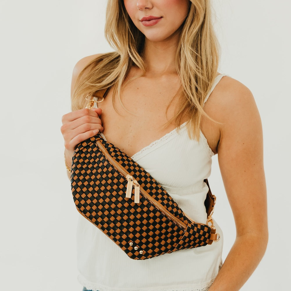 Woven bum bag in black-and-cream check weave with gold zipper and crossbody strap.