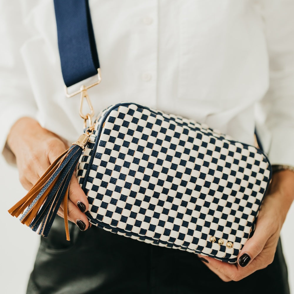 Blue-and-white checkered woven camera crossbody bag with tassel and gold hardware