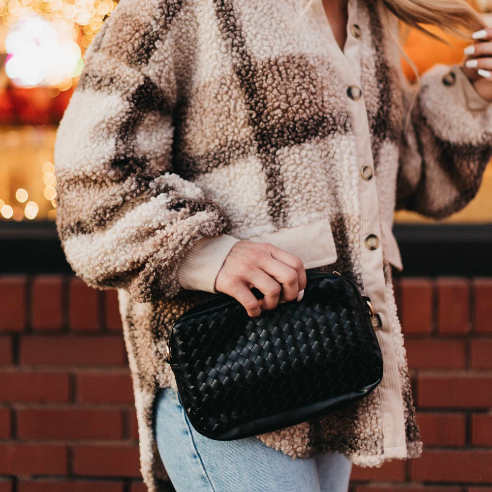 Black woven camera crossbody bag with braided texture and gold zipper pull