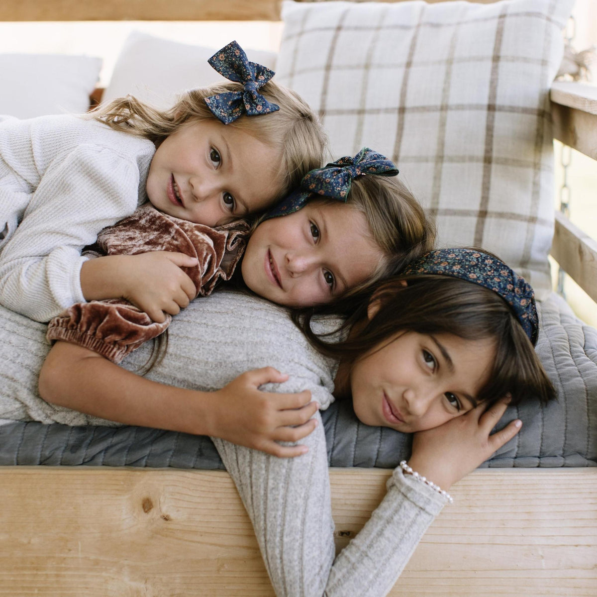 Kids wearing knotted floral headbands, dark teal with orange pattern