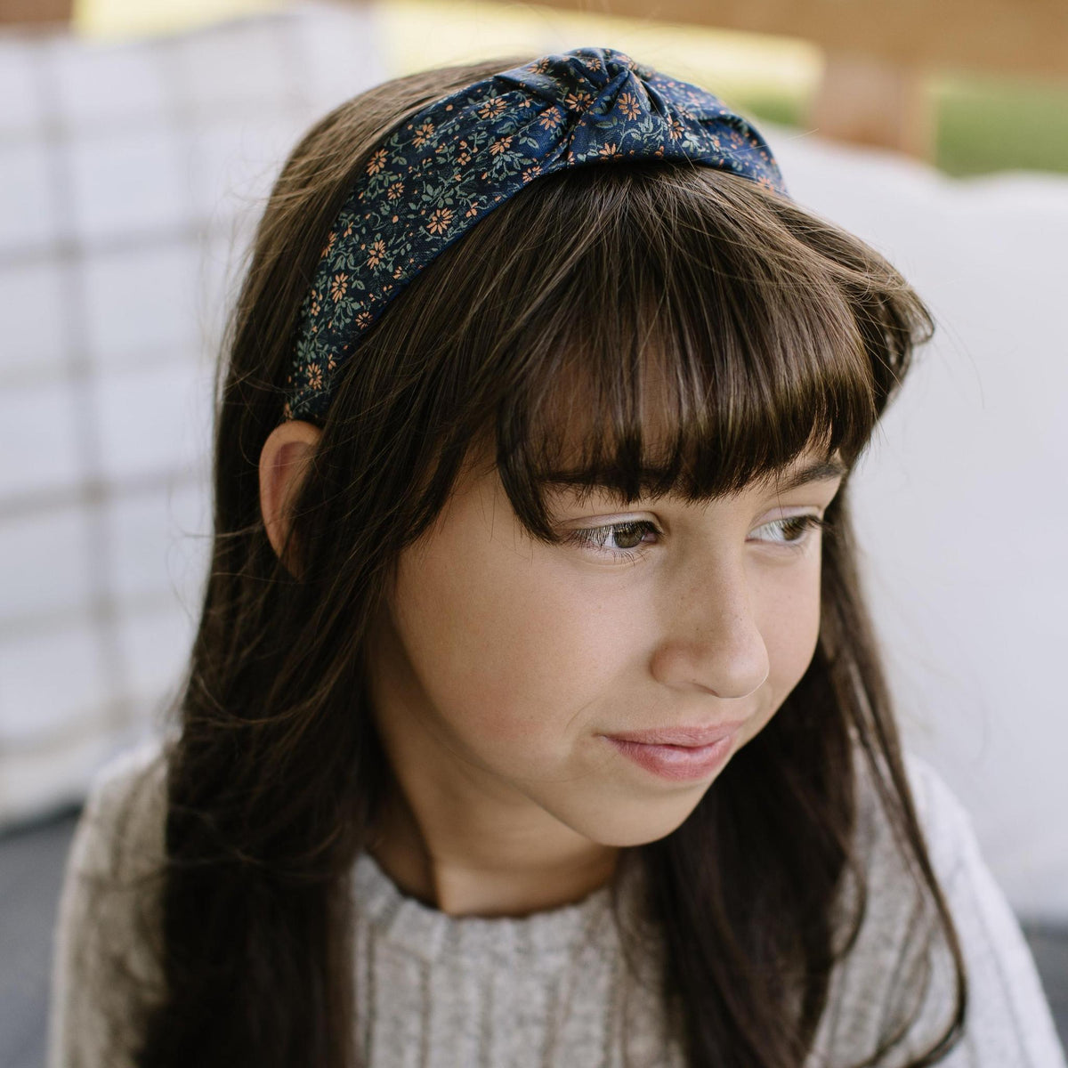 Knotted headband worn, dark teal with orange floral pattern