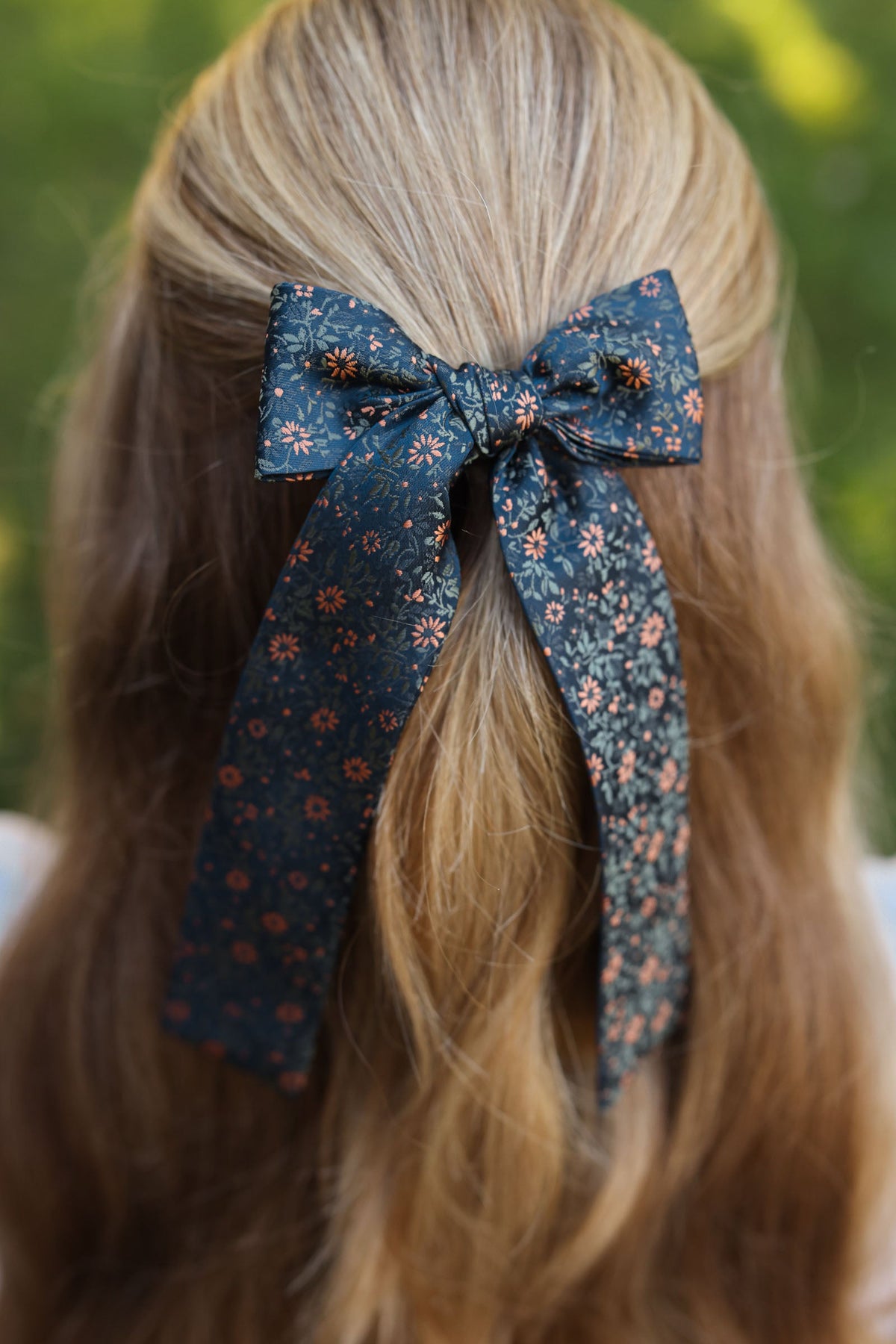 Floral navy hair bow on blonde hair with bow knot and hanging tails
